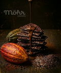 Chocolate drizzle over a stack of chocolate cookies with a cacao pod on a dark background, featuring the brand 'Möhr sweets'.