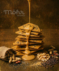 Stack of crackers with a drizzle of caramel sauce on a rustic background, featuring the brand 'Möhr sweets'.
